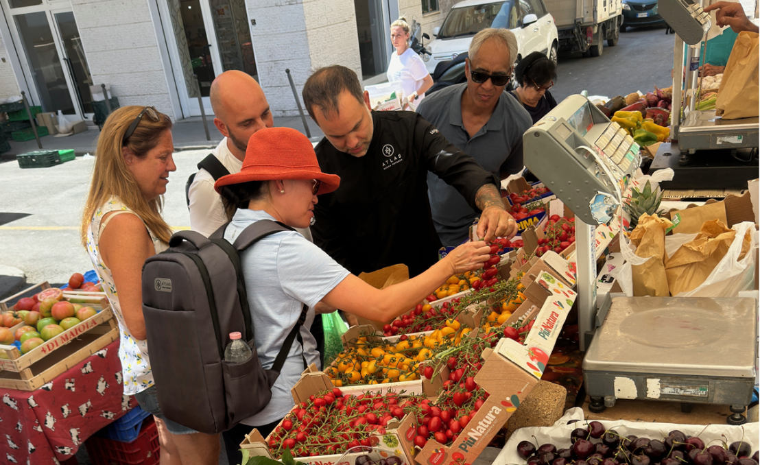 Pessoas a escolher frutas e legumes frescos num mercado local